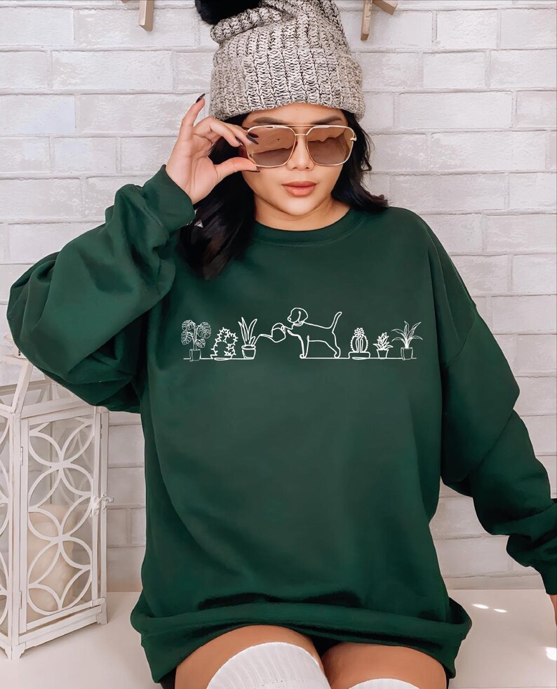 a woman wearing a green sweatshirt and a beanie