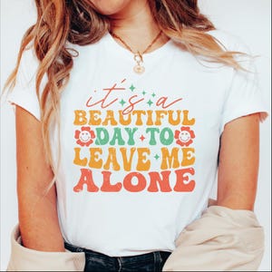 a woman wearing a t - shirt that says it's a beautiful day to