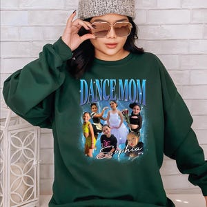 a woman wearing a green sweatshirt and a beanie