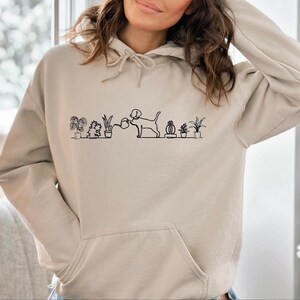 a woman wearing a hoodie with a picture of cats on it