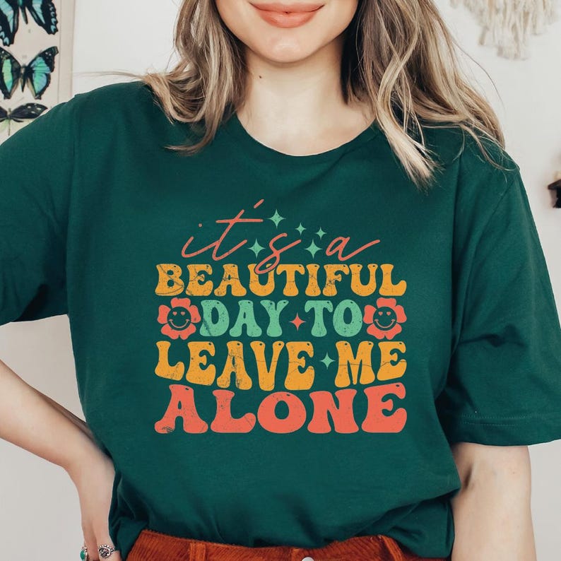 a woman wearing a green shirt that says it's a beautiful day to leave