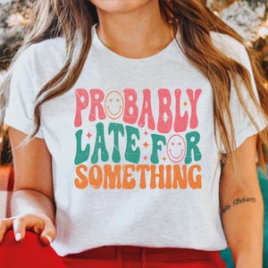 a girl wearing a t - shirt that says probably late for something