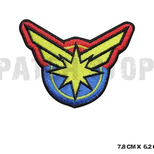 Może przedstawiać: Haftowana naszywka z motywem gwiazdy. Ma żółtą gwiazdę pośrodku, otoczoną niebieskim okręgiem. Projekt zawiera czerwone, żółte i niebieskie akcenty z czarną obwódką. Naszywka ma wymiary 7,8 cm na 6,2 cm.