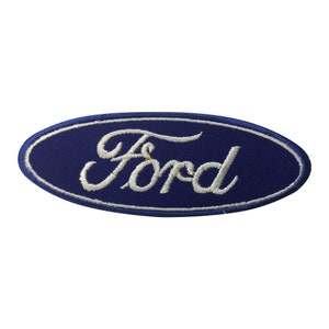 May include: A navy blue oval patch featuring the white embroidered "Ford" logo. The patch has a white border and is designed to be sewn onto clothing or accessories. The design is simple and classic.