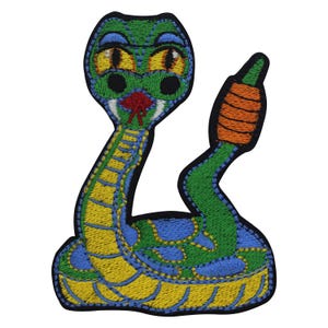 May include: Embroidered patch of a colourful snake. The snake has a green body with yellow and blue details, large yellow eyes, and an orange tail. The patch is outlined in black.