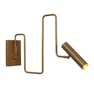 May include: A brass wall-mounted light fixture with a long, adjustable arm and a cylindrical shade. The light is turned on with a switch on the wall plate.