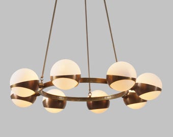 May include: A gold chandelier with a circular frame and eight frosted glass globes. The globes are half white and half gold.