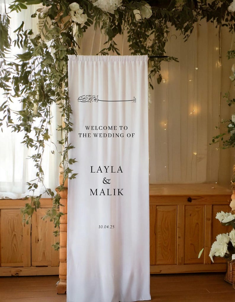 May include: White wedding backdrop with black text that reads "Welcome to the wedding of Layla & Malik 10.04.25".
