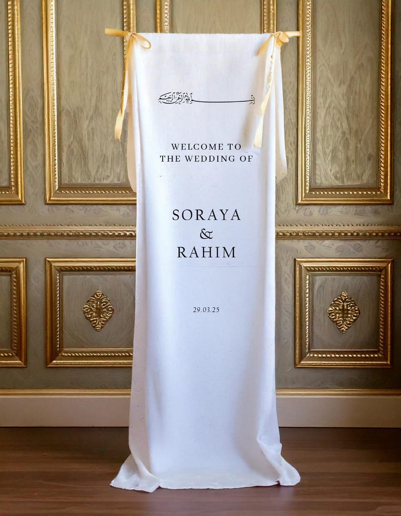 May include: White wedding welcome sign with gold ribbon ties. The sign reads "Welcome to the Wedding of Soraya & Rahim 29.03.25".