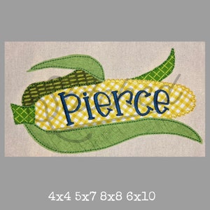 Puede incluir: Diseño bordado de maíz en la mazorca con el nombre "Pierce" en letras azules. El maíz es amarillo con hojas verdes y un patrón a cuadros. El diseño está disponible en los tamaños 4x4, 5x7, 8x8 y 6x10 pulgadas.