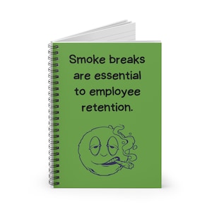 Könnte beinhalten: Grünes Spiralnotizbuch mit dem Text "Smoke breaks are essential to employee retention." und einer Cartoon-Darstellung eines lächelnden Gesichts mit einer Zigarette im Mund.