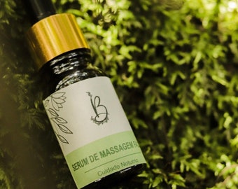 Puede incluir: Un pequeño frasco de vidrio marrón oscuro con tapa dorada y gotero. El frasco está etiquetado con "SERUM DE MASSAGEM FACIAL" y "Cuidado Noturno". El frasco está sentado en un lecho de musgo verde.
