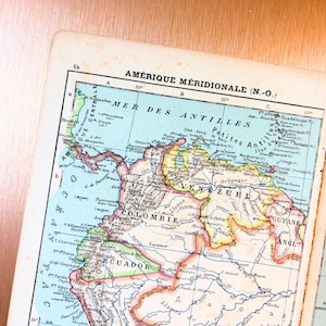 Peut inclure: Une carte géographique ancienne en papier intitulée AMÉRIQUE MÉRIDIONALE représentant le nord de l'Amérique du Sud. La carte affiche des pays comme la Colombie, l'Équateur et le Venezuela avec des bordures pastel, du texte noir et des océans bleus.