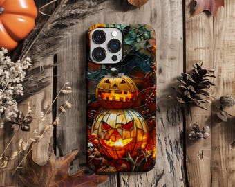 May include: A phone case with a stained glass design featuring two jack-o'-lanterns with glowing eyes. The case has a black background and a colorful stained glass design. The jack-o'-lanterns are orange and have a spooky, Halloween theme.