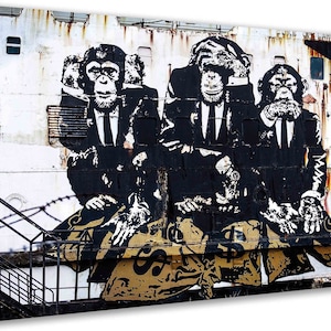 Könnte beinhalten: Drei Schimpansen in Anzügen, die sich jeweils eines ihrer Sinne zudecken, sind in einem Schwarzweiß-Graffiti-Stil auf einer weißen Wand dargestellt. Die Schimpansen halten Geldbeutel.