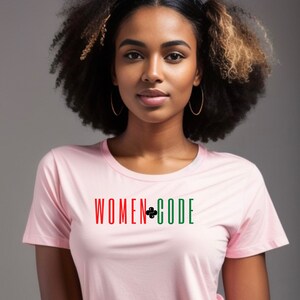 Peut inclure: Un t-shirt rose avec le texte "WOMEN+CODE" en rouge, vert et noir. Le signe plus est un logo Python noir.