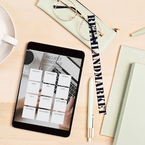 May include: A black tablet with a monthly project schedule calendar on the screen. The calendar is labeled "Project Schedule" and "Arowwai Industrie". The months are January through December.