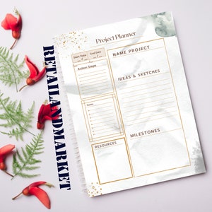 Può includere: Un planner di progetto con sfondo acquerellato e dettagli dorati. Il planner ha sezioni per il nome del progetto, le date di inizio e fine, i passaggi d'azione, le note, le idee e gli schizzi, i traguardi e le risorse.