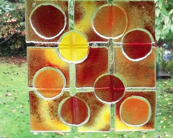 Sonnenfänger aus Glas in in leuchtenden Rot- und Gelbtönen als Gartendekoration oder fürs Fenster zum Aufhängen