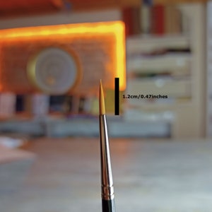 May include: A close-up of a gold paint brush with a 1.2 cm (0.47 inches) diameter brush head.
