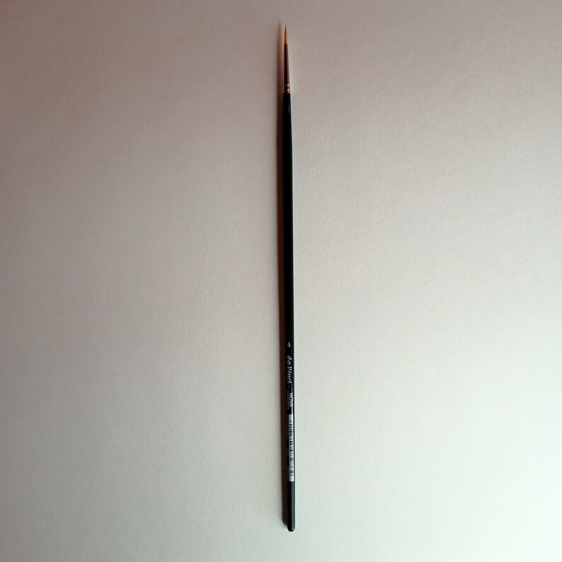 May include: A black and silver paint brush with a fine point.