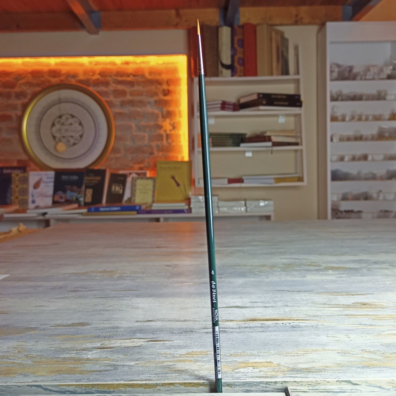 May include: A long, thin, green and gold paintbrush with the text "da Vinci - ROYAL" printed on the side.