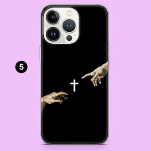 May include: Black phone case with a white cross and two hands reaching towards each other.