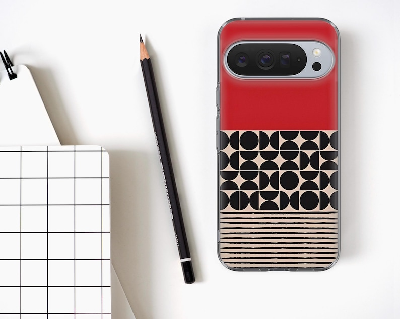 Op de afbeelding: Een rode en patroon telefoonhoesje met een geometrisch ontwerp. De hoes heeft een rood bovenstuk, een middengedeelte met zwarte cirkels en beige vormen, en een onderste gedeelte met beige horizontale lijnen. Een zwarte potlood en een notitieblok staan ook in de afbeelding.