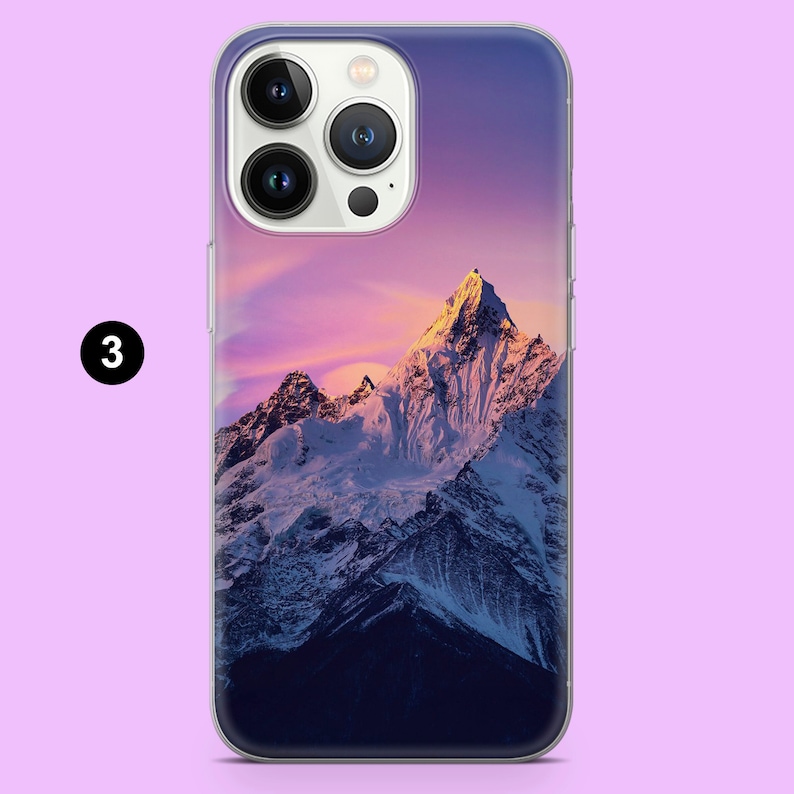 K&ouml;nnte beinhalten: Eine transparente Handyh&uuml;lle mit einem farbenfrohen Bild von schneebedeckten Bergen bei Sonnenuntergang. Die Berge sind in leuchtendem Lila, Rosa und Orange.