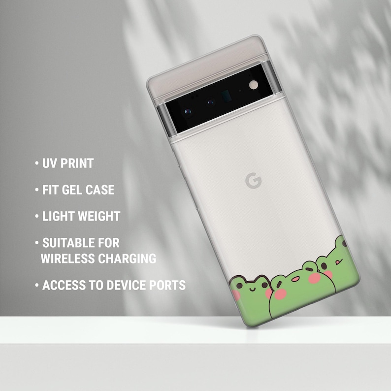 May include: A white phone case with a green frog design. The case is made of gel and has a UV print. It is compatible with wireless charging and has access to device ports.