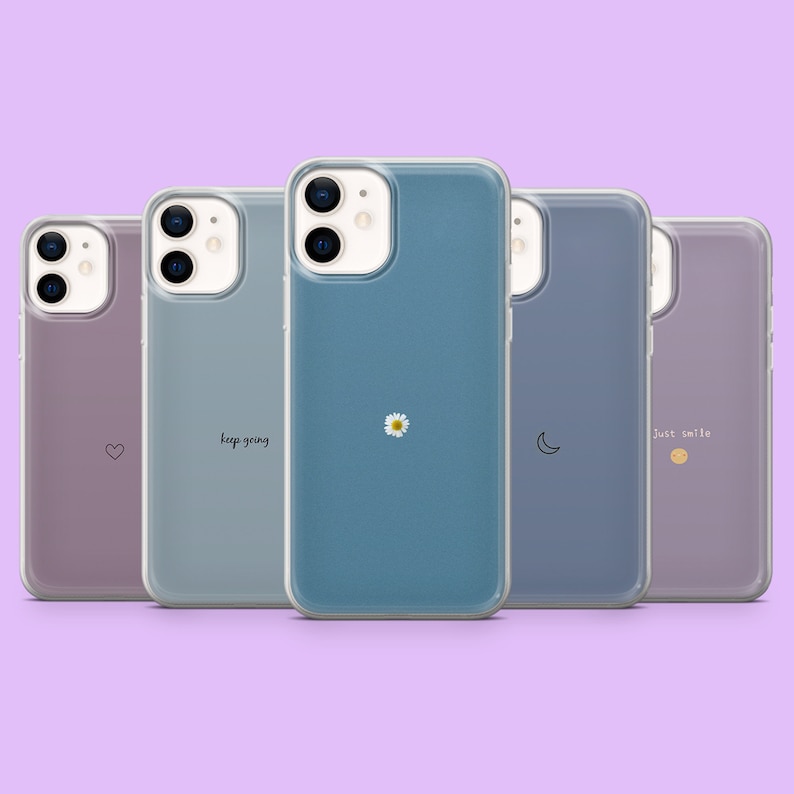 May include: Five clear phone cases with different designs. The cases are all for the iPhone 12 Pro Max. The designs include a heart, the words "keep going", a daisy, a crescent moon, and the words "Just smile".