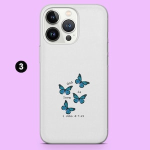 May include: White phone case with a clear back. The case has a design of blue butterflies and the text "God is love 1 John 4:7-21".