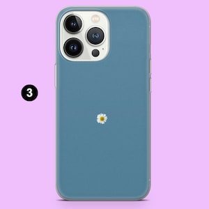 May include: A blue phone case with a white daisy design. The case is made for an iPhone 14 Pro.