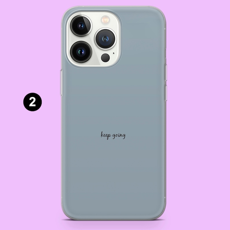 May include: A light blue phone case with a clear back and a camera bump. The case has the text "keep going" printed on the back.