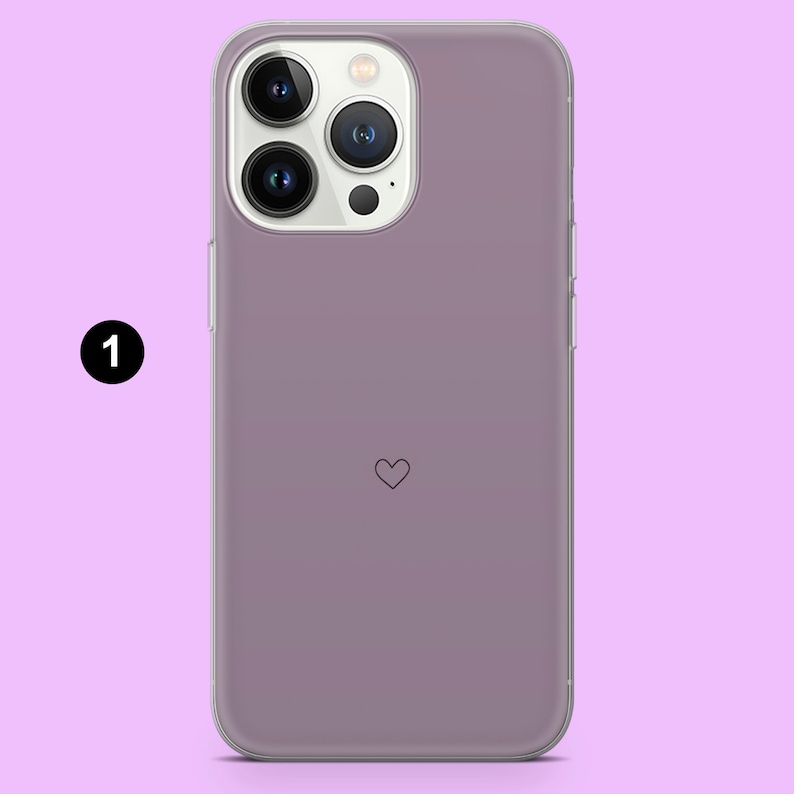 May include: A clear phone case with a light purple tint and a small heart design. The case is designed for an iPhone.