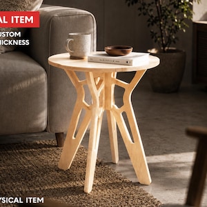 May include: A light wood side table with a round top and a unique, open-work base. The table has a natural finish and is approximately 24 inches in height. A mug, a small bowl, and a book are on the table. The text "DIGITAL ITEM" and "FREE CUSTOM SIZE & THICKNESS" are visible.