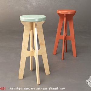 May include: Two wooden stools, one with a light green top and the other with an orange top. Both stools have a simple, modern design with a triangular base.