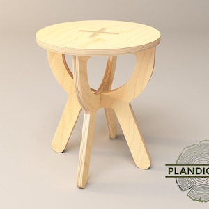 Può includere: Uno sgabello in legno chiaro con un piano rotondo e tre gambe. Le gambe sono a forma di croce.