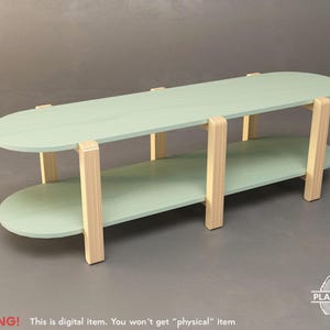 May include: A two-tiered, oval-shaped coffee table. The top and bottom surfaces are a pale green, supported by natural wood-colored legs. The table is approximately 48 inches long and 24 inches wide. The text "WARNING! This is digital item. You won't get "physical" item" is at the bottom.
