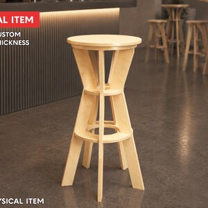 May include: A light-colored wooden bar stool with a round top and a unique, open-frame design. The stool has a sturdy base and two supporting shelves. The text "DIGITAL ITEM" and "FREE CUSTOM SIZE & THICKNESS" is visible. The words "NO PHYSICAL ITEM" are also visible.