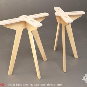 Op de afbeelding: Twee houten tafelpoten met een kruisvormige bovenkant. De poten zijn gemaakt van licht hout en hebben een eenvoudig, modern ontwerp.