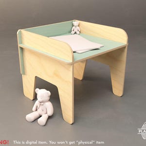 May include: A light wood-colored changing table with a mint green top and accents. Two small white teddy bears are placed on and near the table. The table has a rectangular shape with rounded edges and a shelf on the side. The text "WARNING! This is digital item. You won't get "physical" item" is at the bottom.