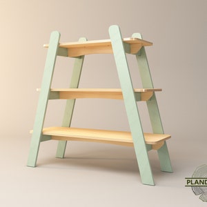 Puede incluir: Estantería de madera de tres niveles con estructura verde claro y estantes de madera natural. El diseño en forma de A proporciona estabilidad. Los estantes miden aproximadamente 76 cm de ancho, ideales para exhibir objetos.