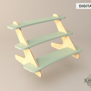 May include: A three-tiered wooden shelf unit with a light green finish. The shelves are curved and the legs are angled. The shelf unit is made of plywood and is designed to be assembled.