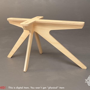 Op de afbeelding: Een houten tafelpoot met een uniek, modern ontwerp. De poot is gemaakt van multiplex en heeft een natuurlijke houtkleur. De poot is stervormig met vier punten en een centraal platform.