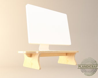 May include: A light wood computer monitor stand with rounded edges. The stand is made of plywood and has a simple design. The stand is designed to raise a computer monitor to a more ergonomic height.