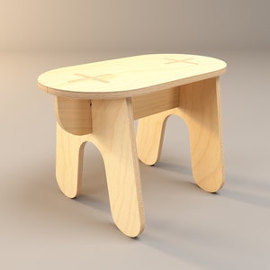 Puede incluir: Un pequeño taburete de madera clara con un asiento ovalado y cuatro patas curvas. El asiento presenta dos diseños en forma de cruz incrustados. El taburete está hecho de madera natural y tiene un diseño simple y minimalista.