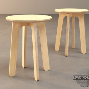 Puede incluir: Dos mesas auxiliares de madera clara con tapa redonda y cuatro patas. Las mesas están hechas de madera contrachapada y tienen un acabado de madera natural.