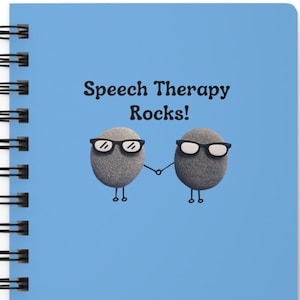 May include: A blue spiral bound notebook with the text "Speech Therapy Rocks!" and a cartoon image of two gray rocks wearing glasses and holding hands.