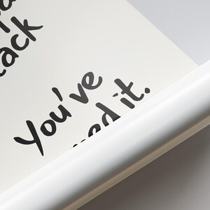 May include: A close-up of a white poster with black handwritten text that reads "You've...ed it." The poster is partially rolled, revealing a white edge. The background is a light gray.